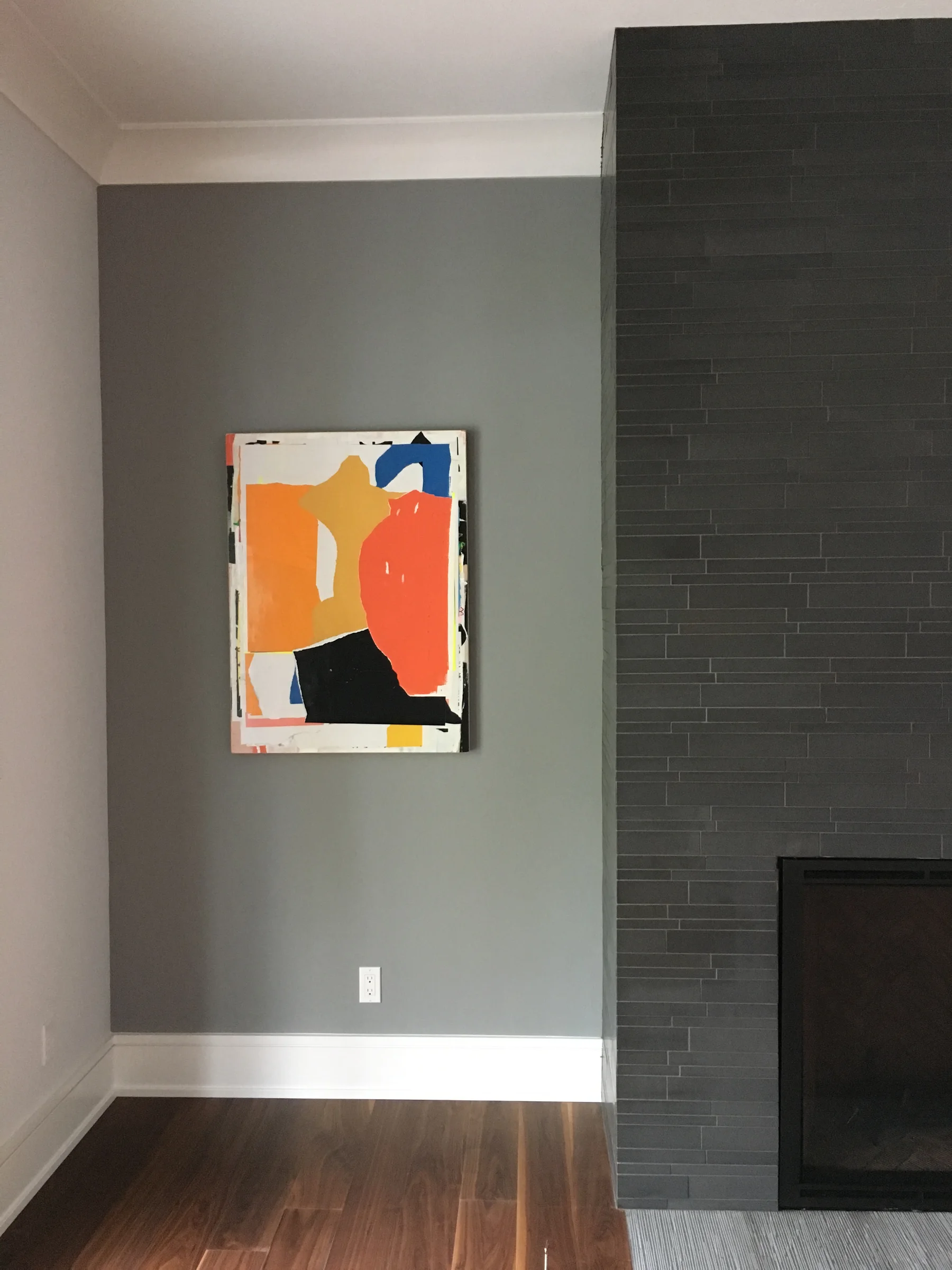 Colorful abstract artwork beside a dark tiled fireplace