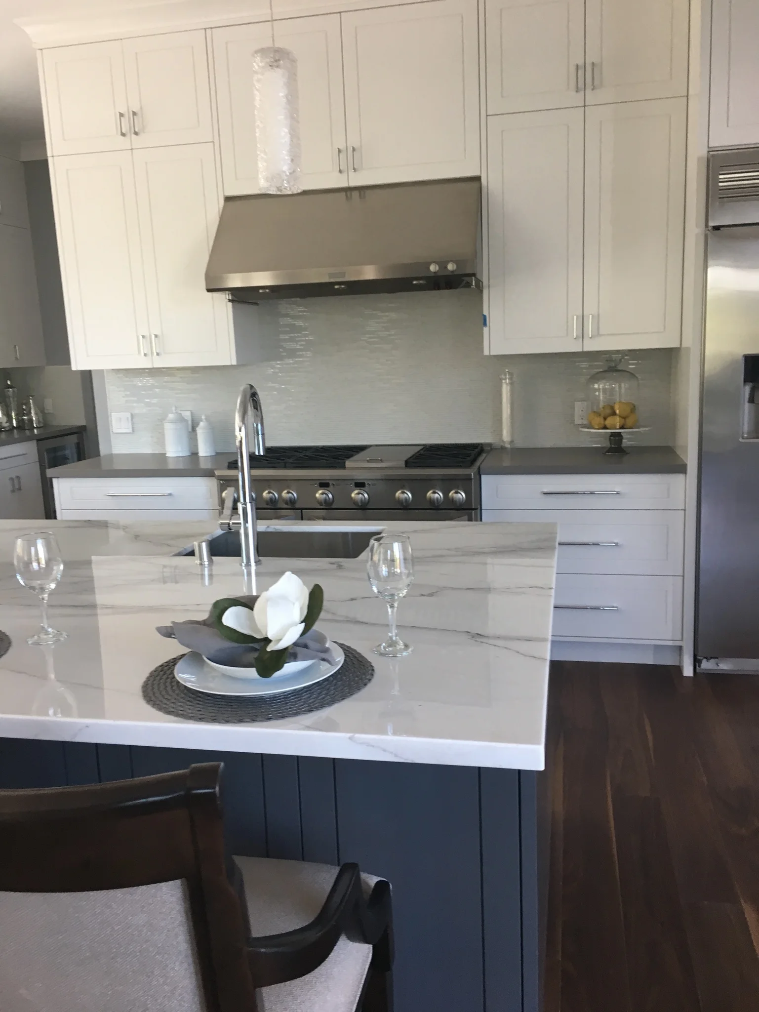 White kitchen with a marble island set for dining