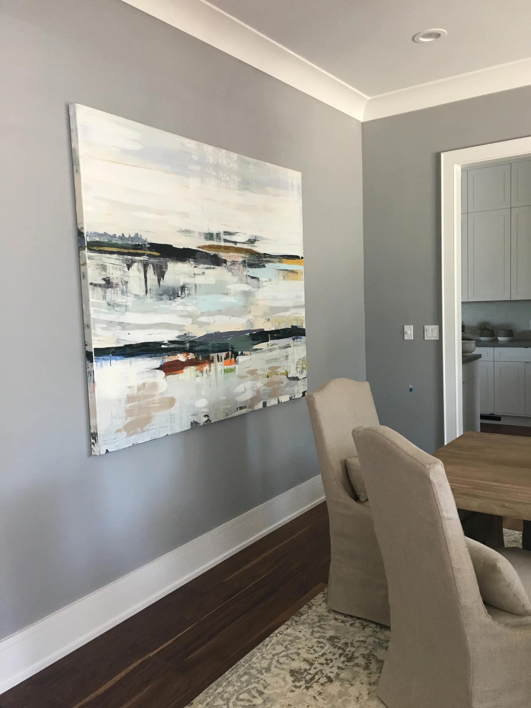 Large abstract painting displayed in a gray dining room