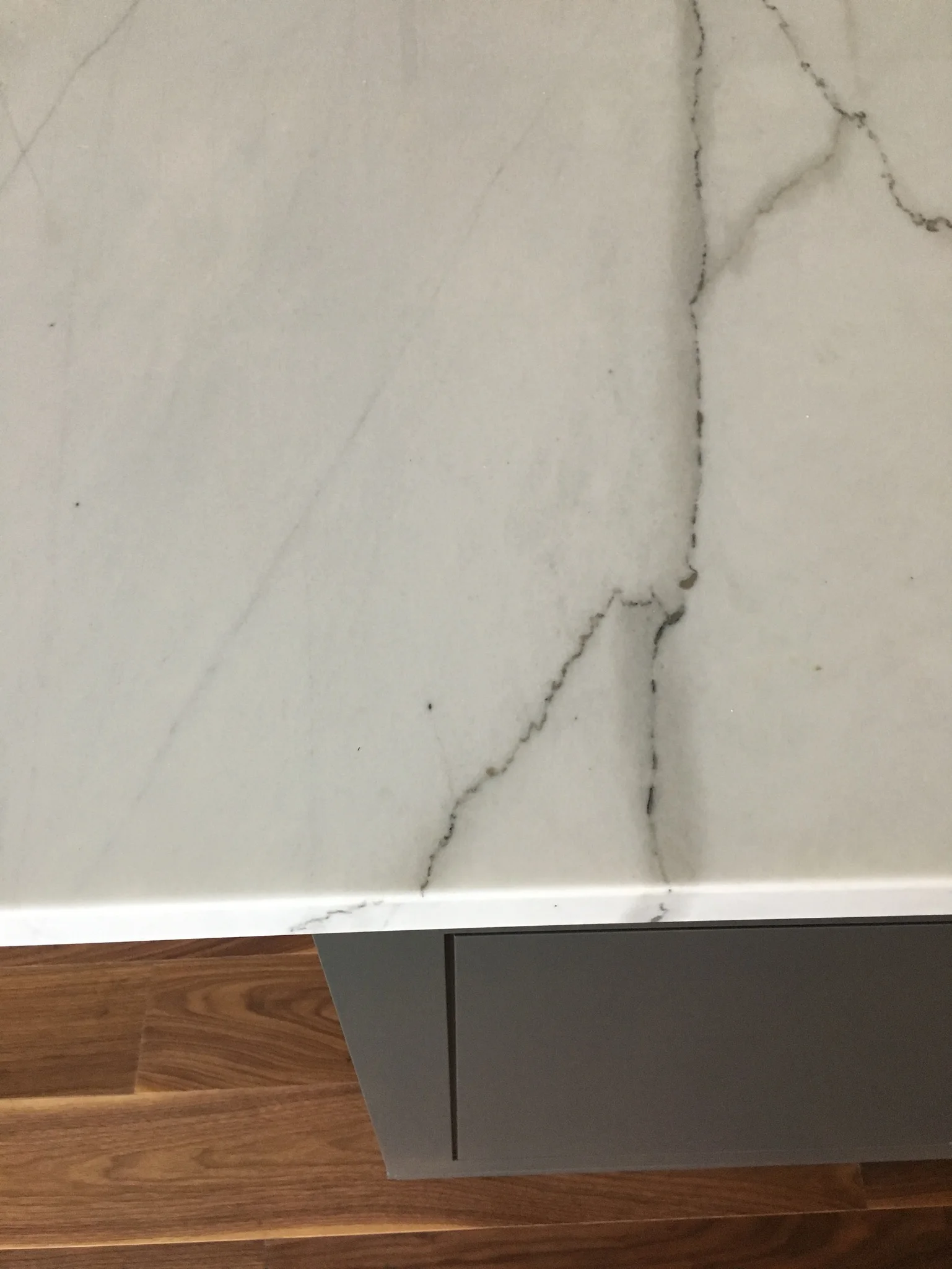 Close view of a white stone countertop with dark veining