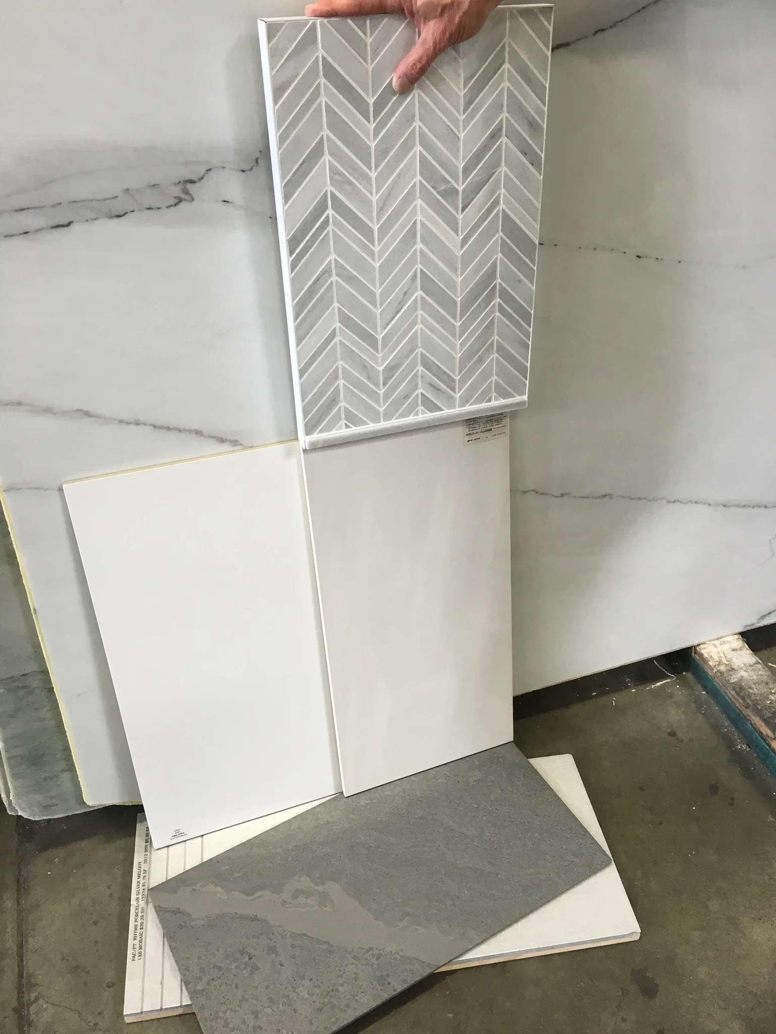 White and gray tile samples including herringbone and marble patterns
